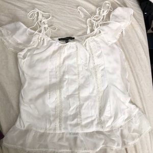 Light cream colored sleeveless blouse.